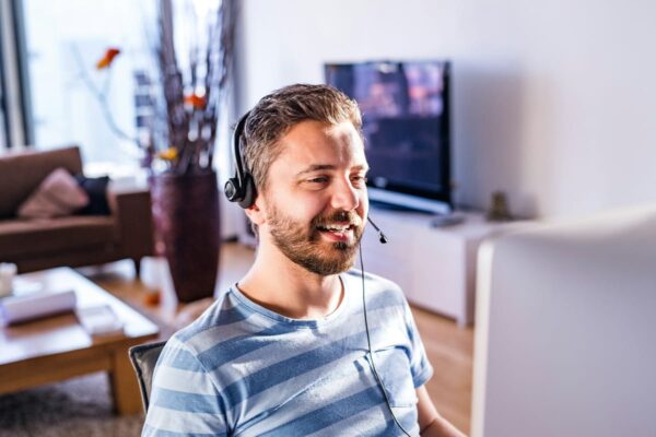 Kopfhörer für Home Office mit Mikrofon im Einsatz bei Videomeeting Mann mit Kopfhörer für Home Office und Mikrofon beim Videocall