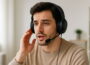 Junge Person mit Kopfhörer zum Telefonieren bei einem Anruf im Home-Office