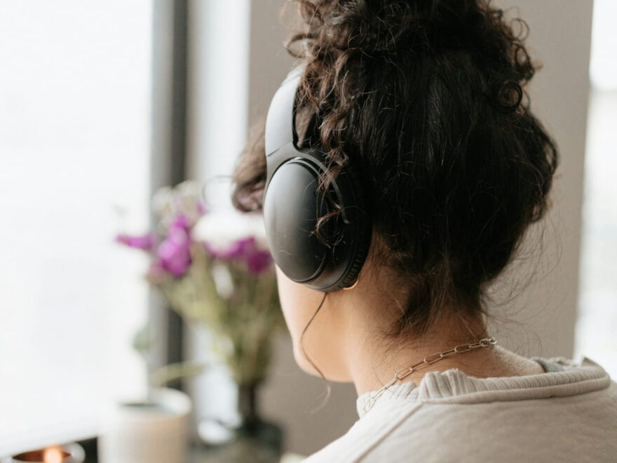 Person hört konzentriert Musik mit Kopfhörern – guter Klang bei Kopfhörern ist subjektiv